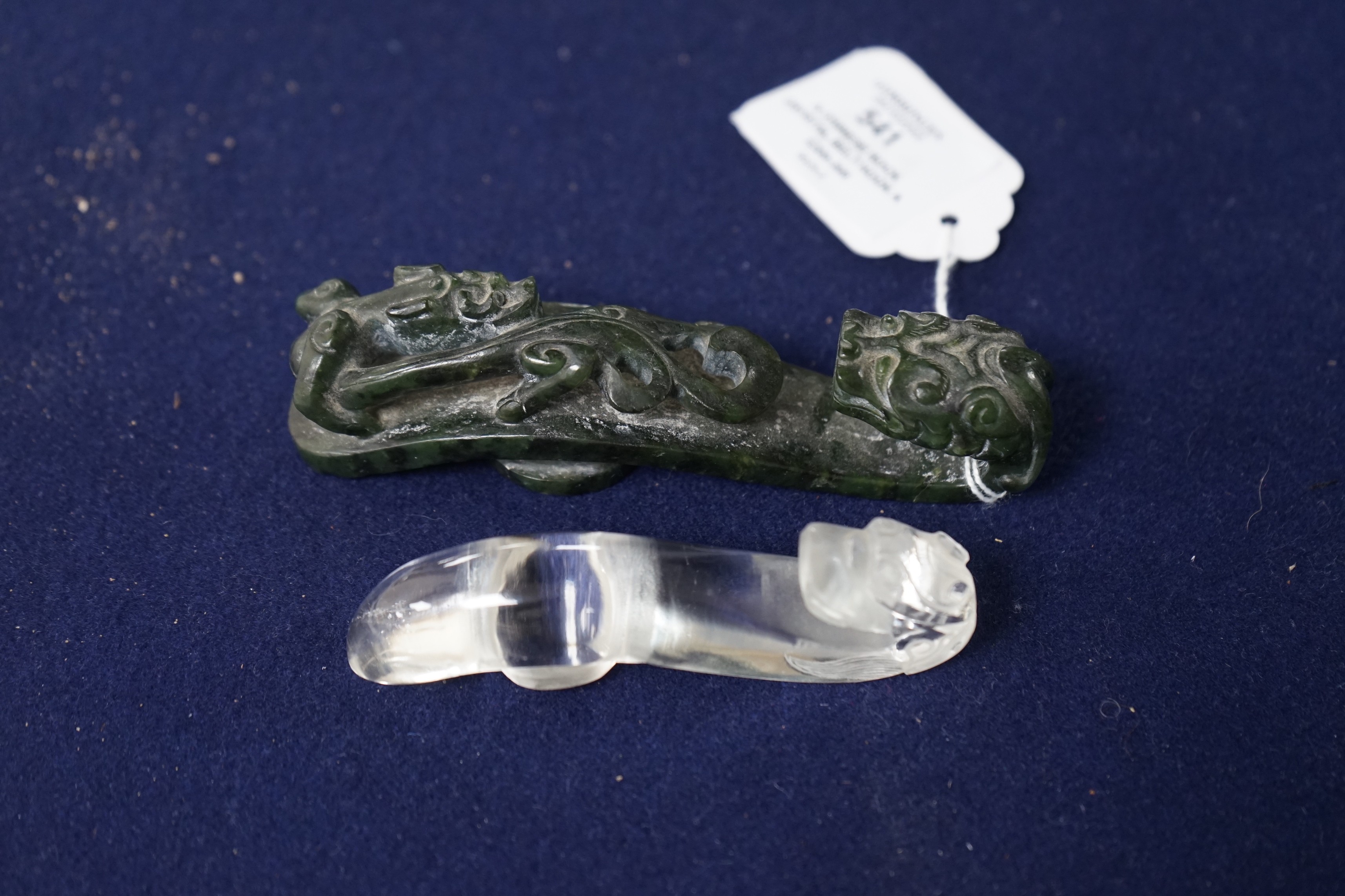 A Chinese rock crystal belt hook and a Chinese spinach green jade belt hook (2), largest 12cms long